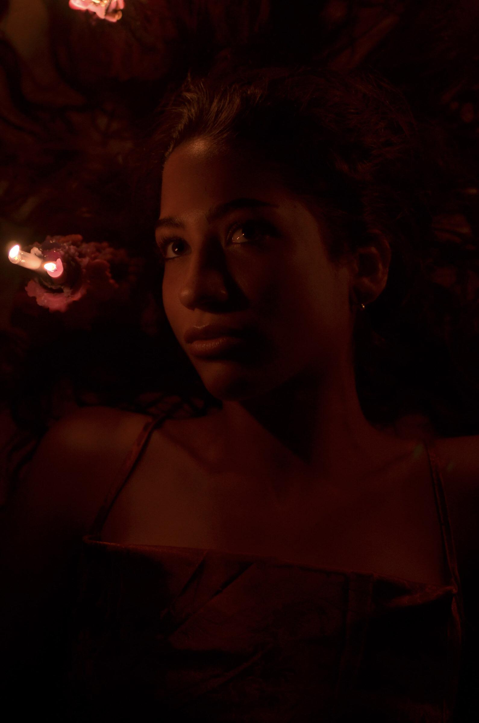Candlelit face in the red dark