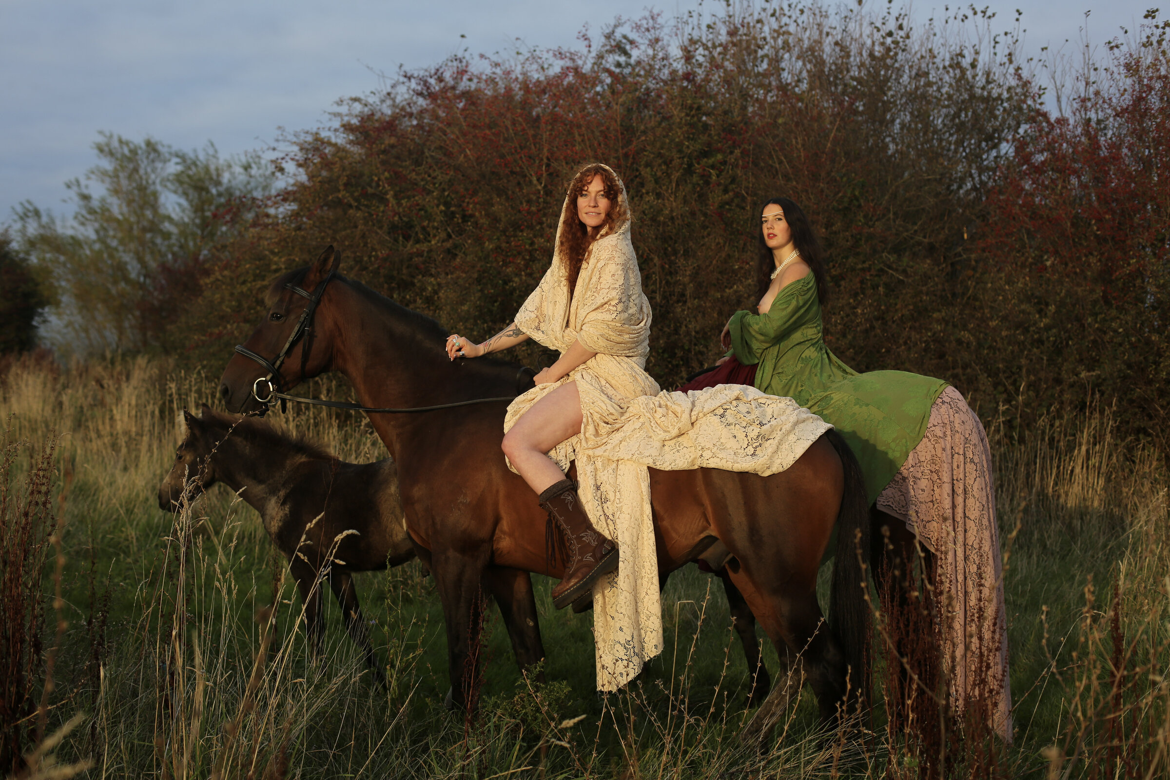 Two riders in gowns among the brush