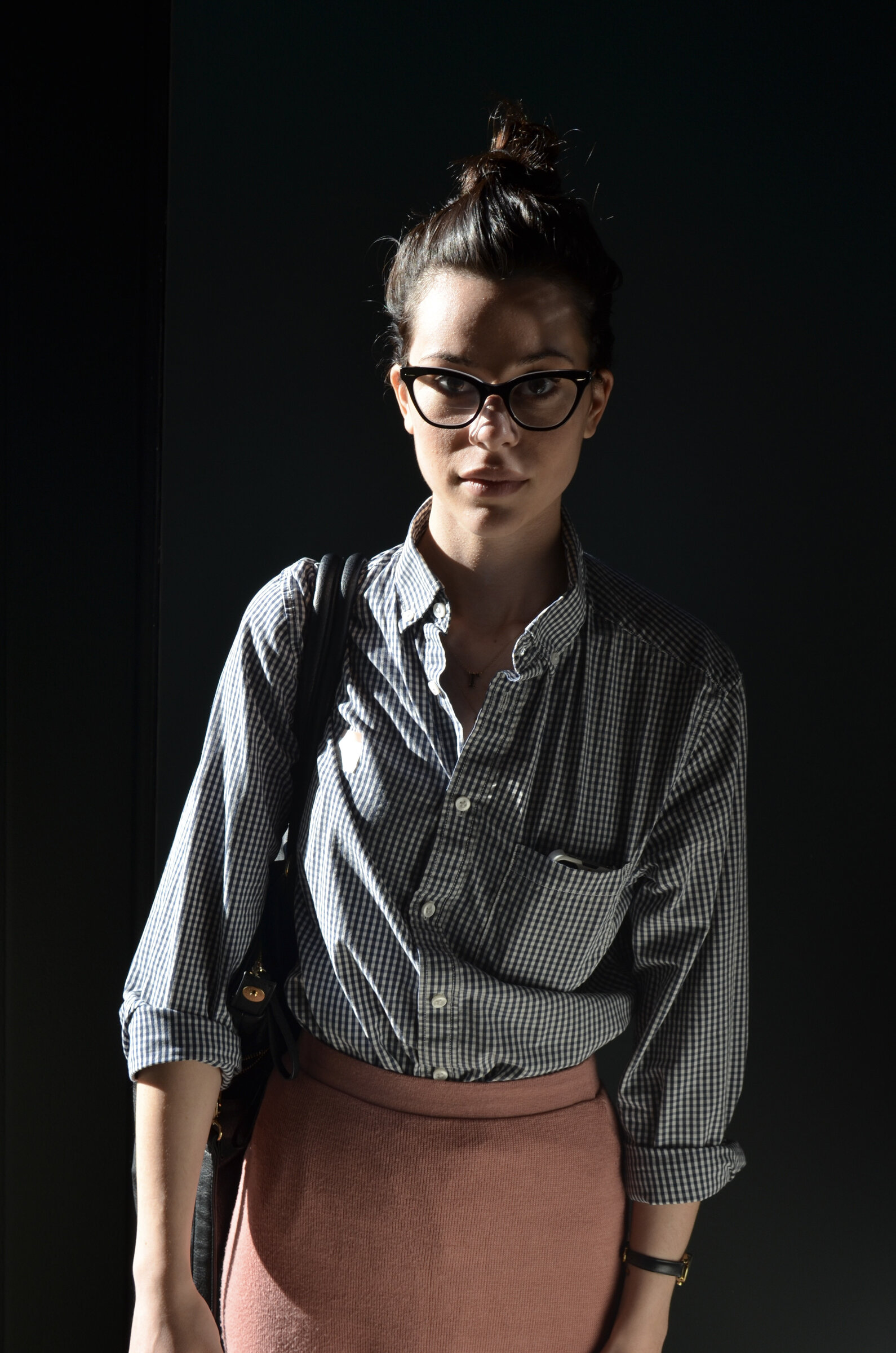 Studio portrait, woman in glasses against black
