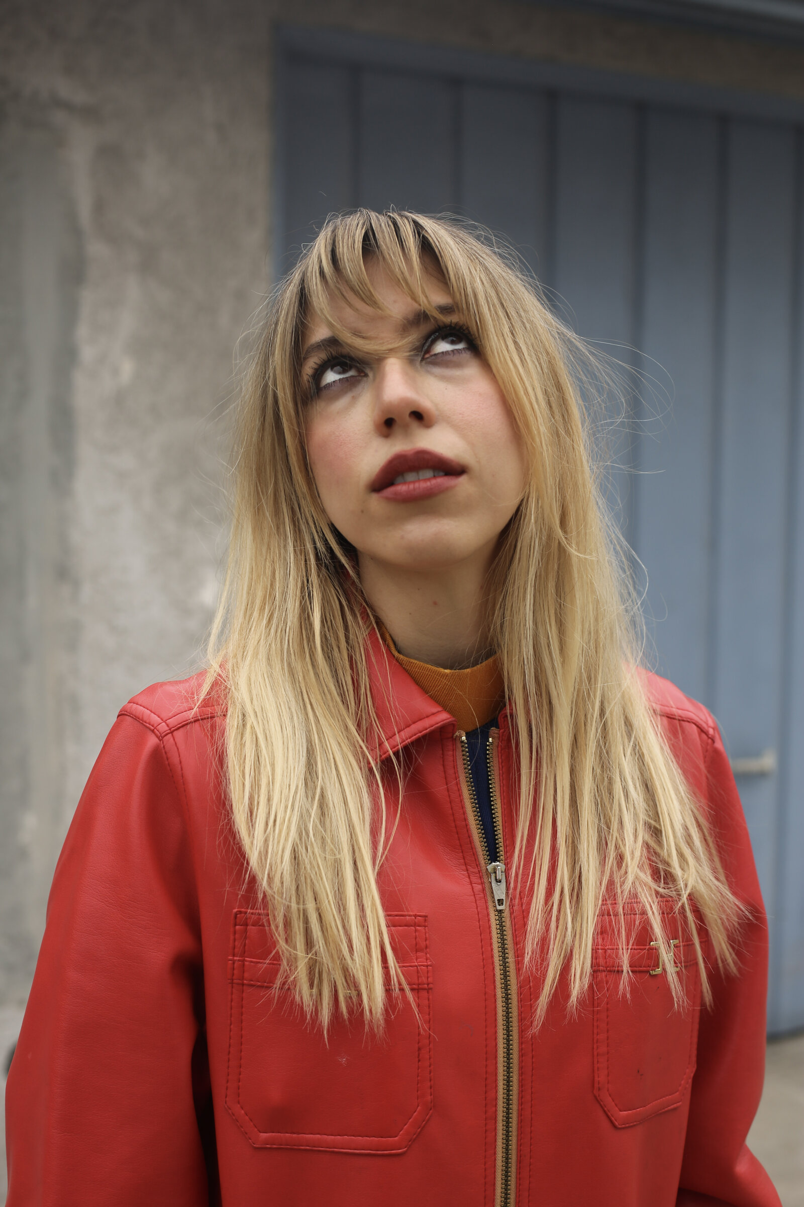 Blonde in a red jacket, looking up