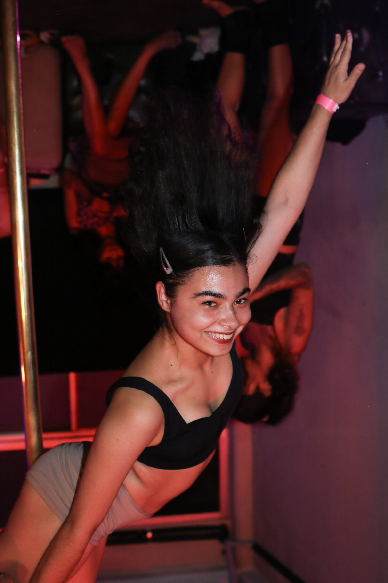 Dancer upside down on the pole, red room