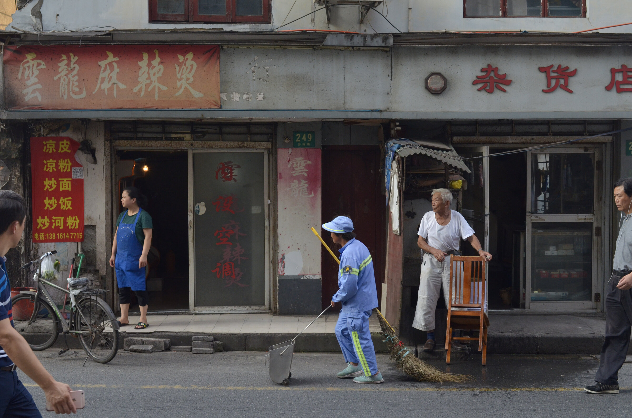 Corner shop with red signage, street life